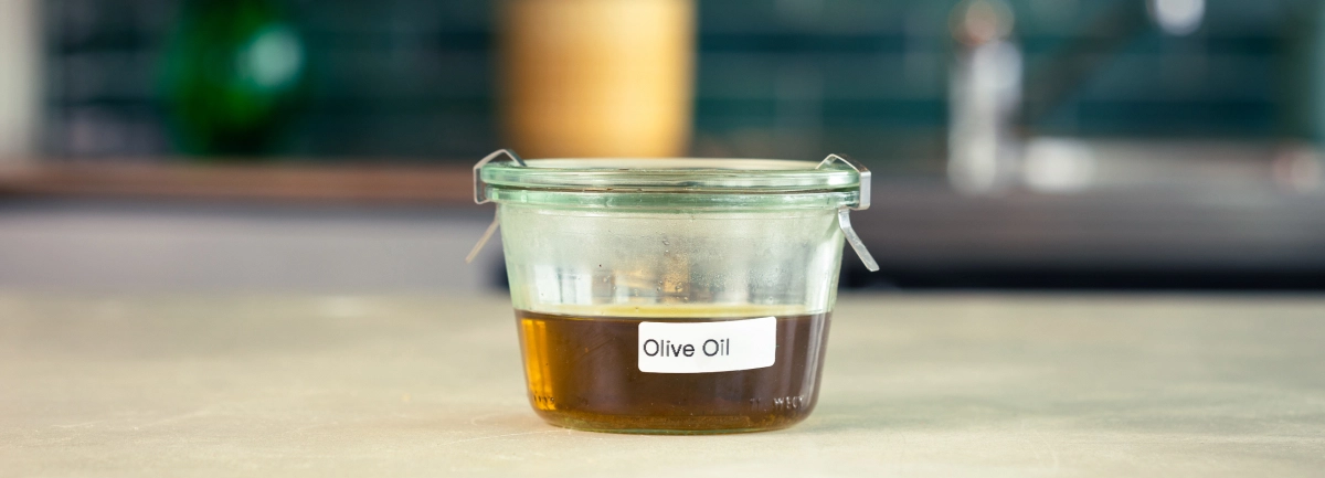 Opbevaring af cannabisinfuseret olivenolie Glasbeholder med cannabisinfuseret olivenolie, mærket og klar til opbevaring.