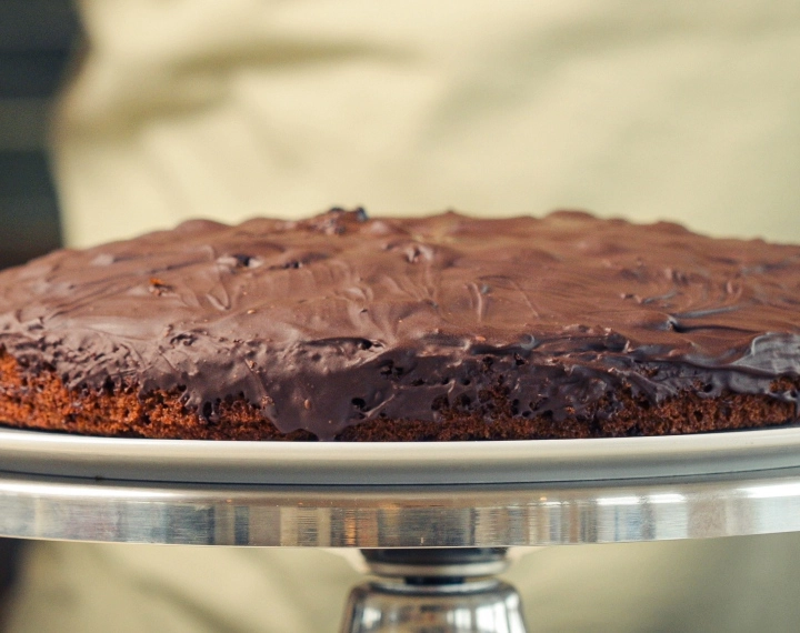 Færdig hjemmelavet cannabis space cake toppet med smeltet mørk chokolade, serveret som en klassisk edible-dessert